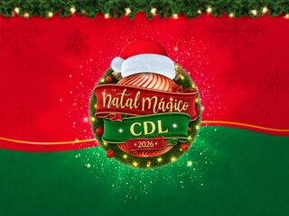 Selo do Natal Mágico CDL 2026 sobre guirlanda iluminada com gorro de Papai Noel, em fundo vermelho e verde com flocos de neve