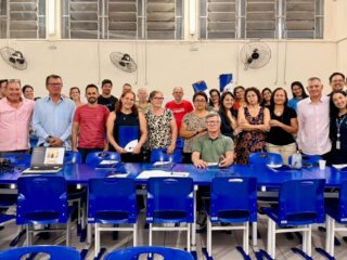 Grupo de comerciantes da Grande Goiabeiras e representantes da CDL Vitória reunidos em sala da EMEF Adão Benezath, em Vitória, durante a apresentação do Natal Mágico CDL 2026